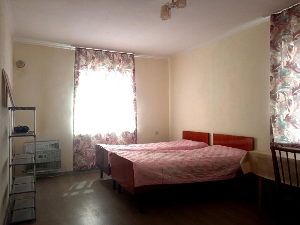 a bedroom with a bed and a large window at Guest house with two rooms in Zugdidi