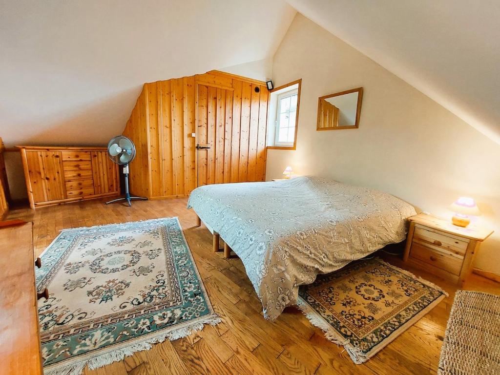 une chambre avec un lit et un parquet dans l'établissement Gîte et gîte équestre dans ancienne laiterie rénovée, à Saint-Sauveur-le-Vicomte