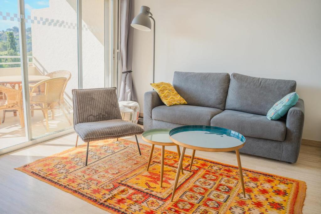 un salon avec un canapé, une table et des chaises dans l'établissement Soléna - Appartement Vue Mer Climatisé 2 Chambres, à Cavalaire-sur-Mer