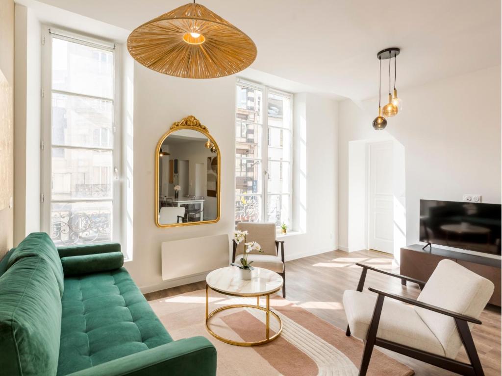 - un salon avec un canapé vert et un miroir dans l'établissement Merveil - Family Suite - Marais - Fbg St Antoine, à Paris