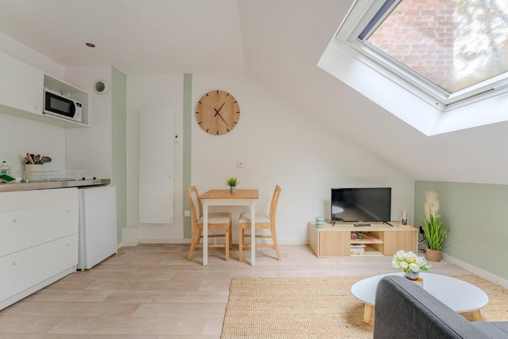 - un salon avec une table et une horloge murale dans l'établissement Bright Studio for 2 : Lille City-center, à Lille