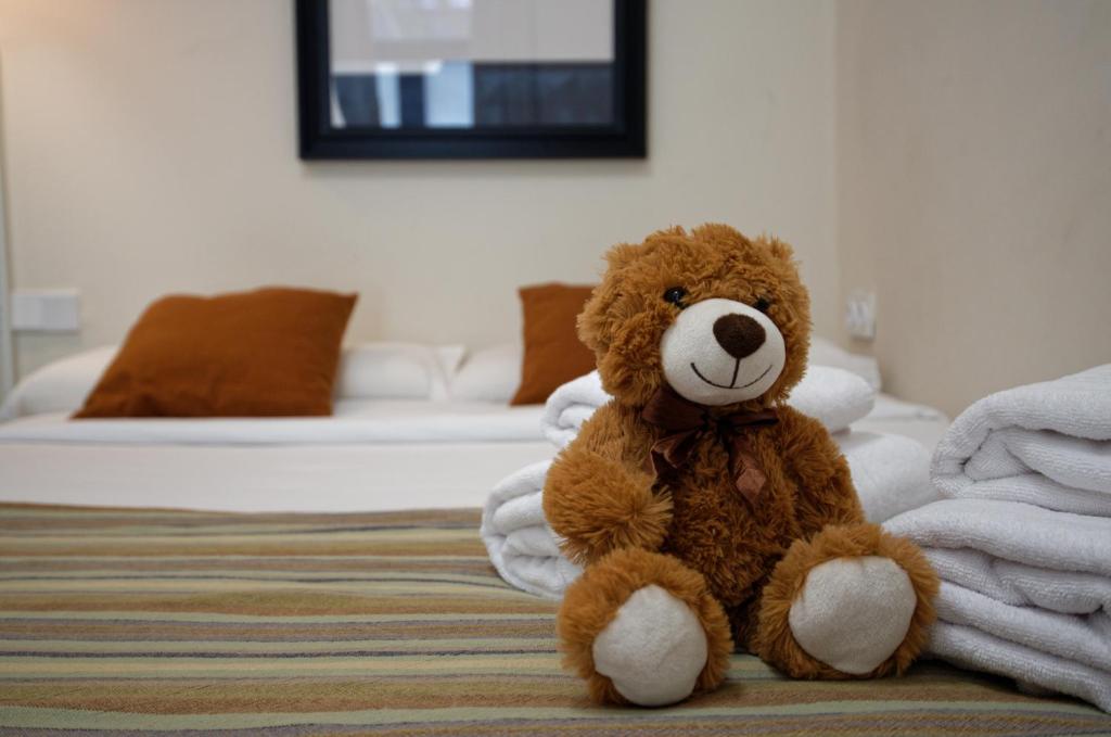 a brown teddy bear sitting on a bed at Osito Hub - Campoamor in Valencia