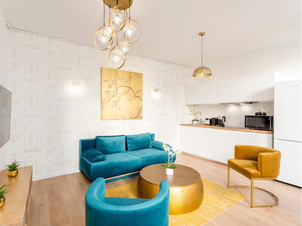 un salon avec un canapé bleu et une table dans l'établissement Merveil - Family Suite - Louvre - Sainte Anne, à Paris