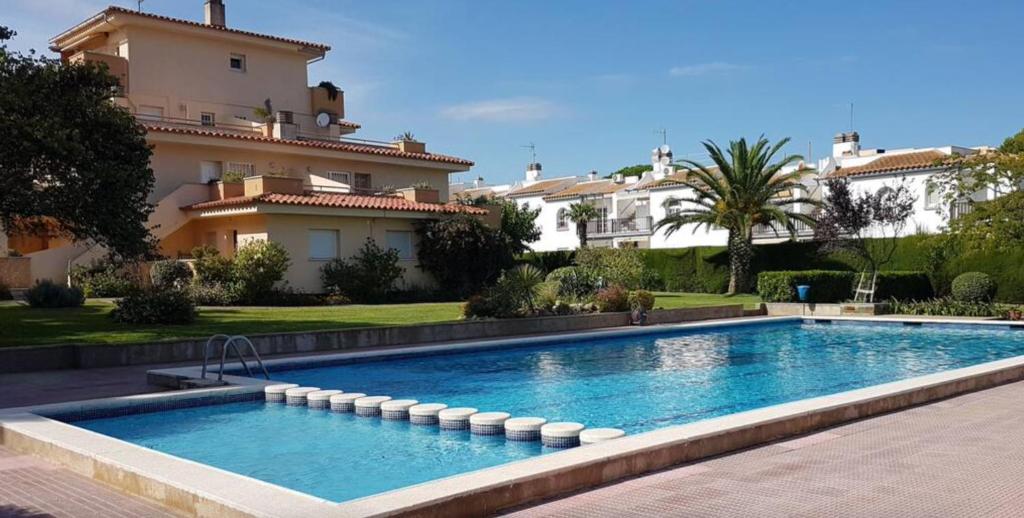 a swimming pool in front of a house at Stil Mar Anna Blue - by Apartamentos Stil Mar Anna in L'Escala