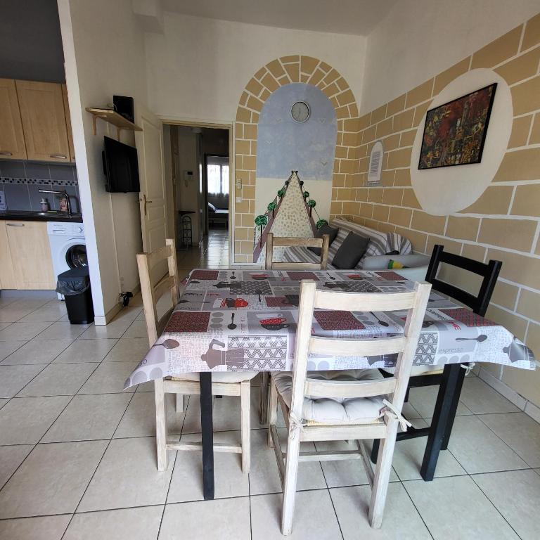 une cuisine avec une table et des chaises dans une pièce dans l'établissement Cœur d'azur, à Saint-Laurent-du-Var