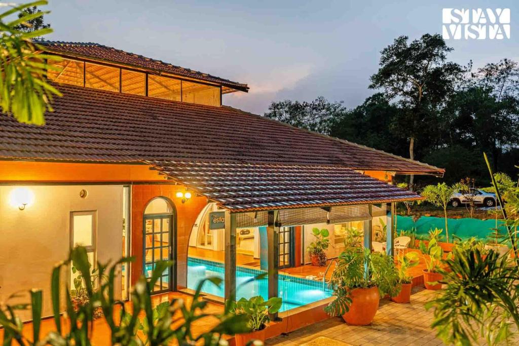 a house with a swimming pool in front of it at The Estate Villa Where Luxury Meets Serenity in Suntikoppa