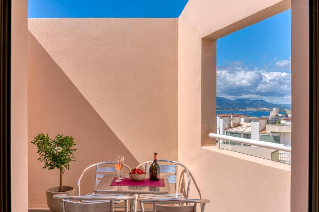 une table et des chaises sur un balcon avec une fenêtre dans l'établissement Duplex centre de Cannes - terrasse, sunset & pool, à Cannes
