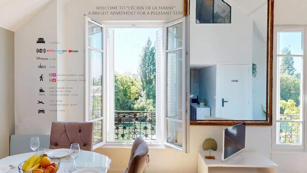 a dining room with a table and a large window at Appartement 3 pièces proche Paris & Disney in Nogent-sur-Marne