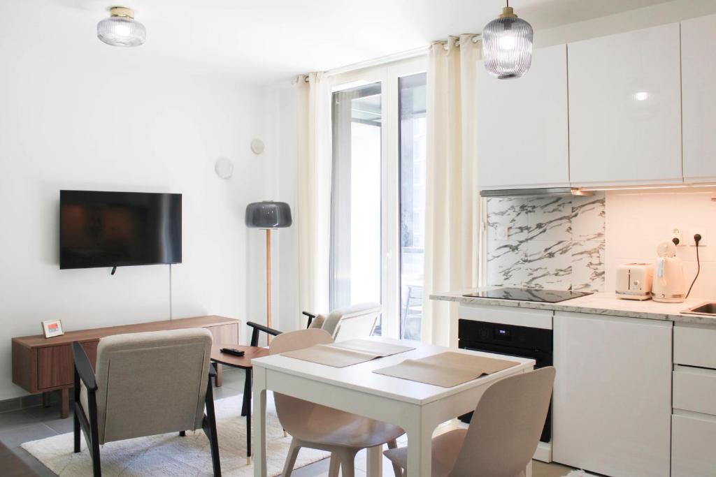 une cuisine et une salle à manger avec une table et des chaises dans l'établissement Bright apartment in Asnières-sur-Seine, à Asnières-sur-Seine