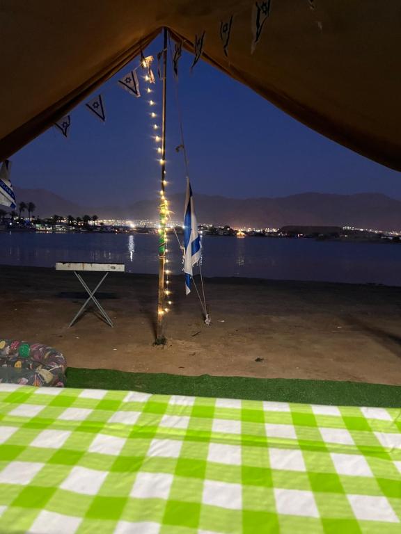 Zelt mit Blick auf das Wasser in der Nacht in der Unterkunft קרוואן על הים in Eilat