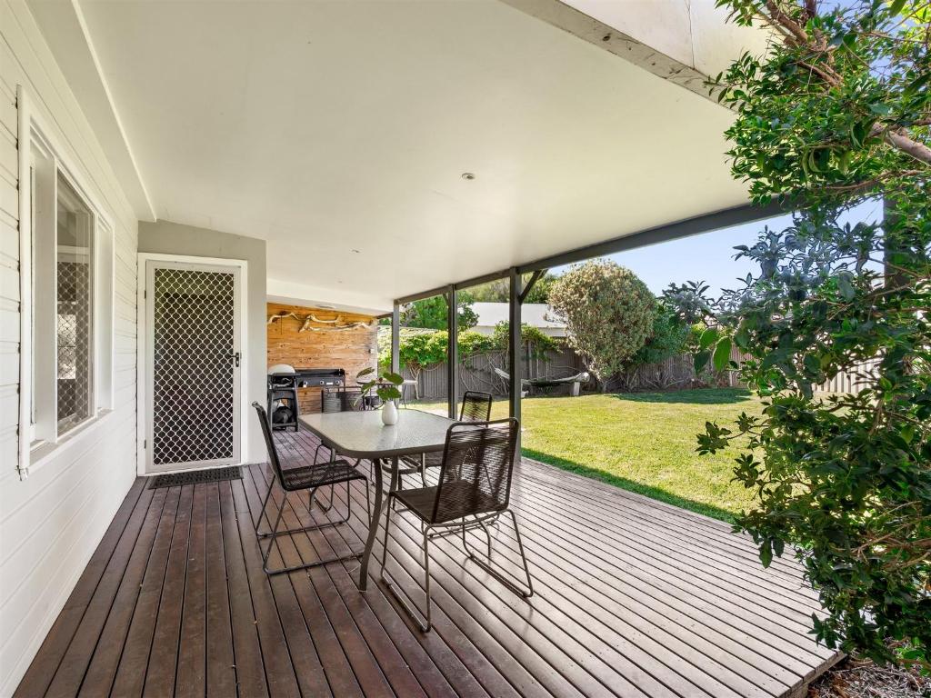 a wooden deck with a table and chairs on it at Margs In Mandurah- Classic Family Holiday Abode! in Dawesville