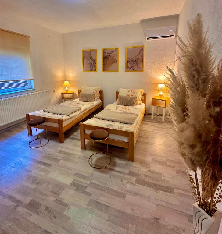 a room with two beds and a plant in it at Apartment Rea Ilidža 2 in Sarajevo