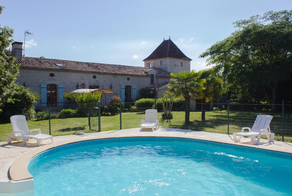 una piscina con due sedie e una casa di CAPE - maison avec piscine et jacuzzi a Thénac