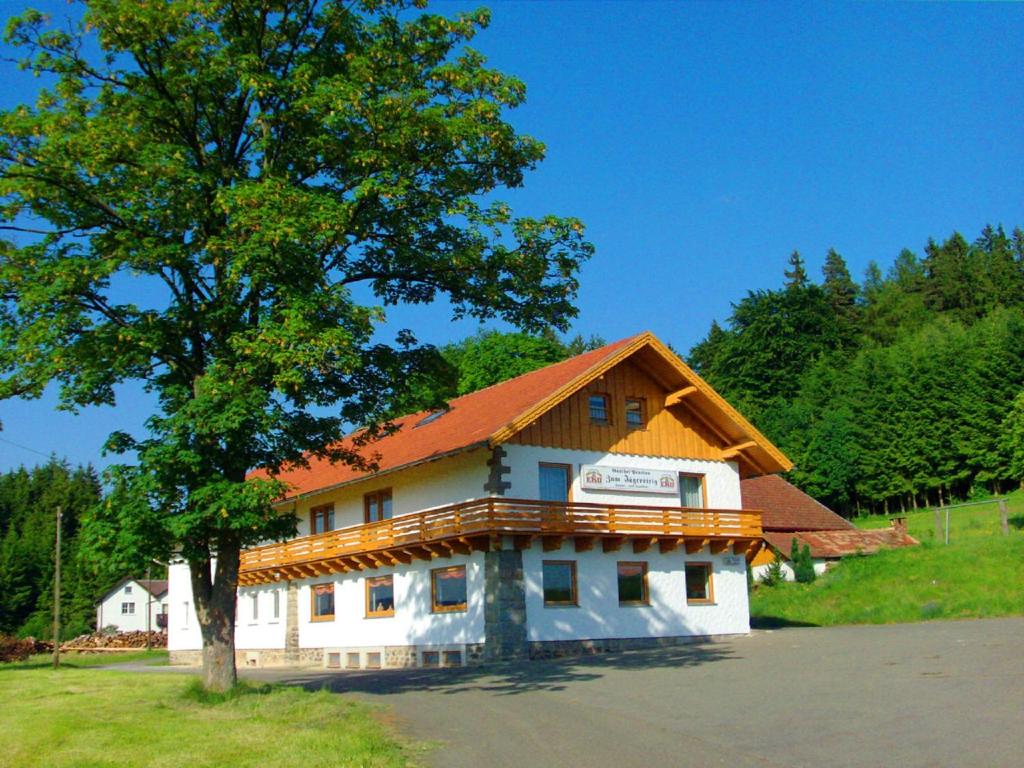 budynek z pomarańczowym dachem i drzewem w obiekcie Ferienhof Jägersteig w mieście Waldmünchen
