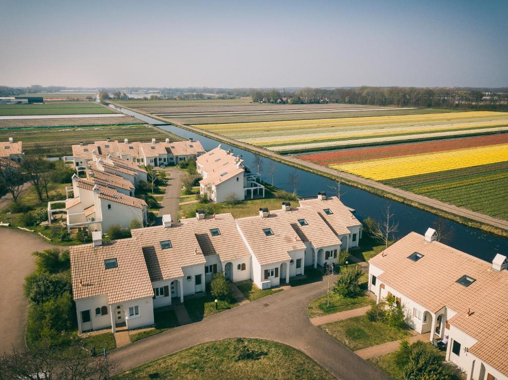 an aerial view of a row of houses next to a field at Duinresort Dunimar in Noordwijkerhout
