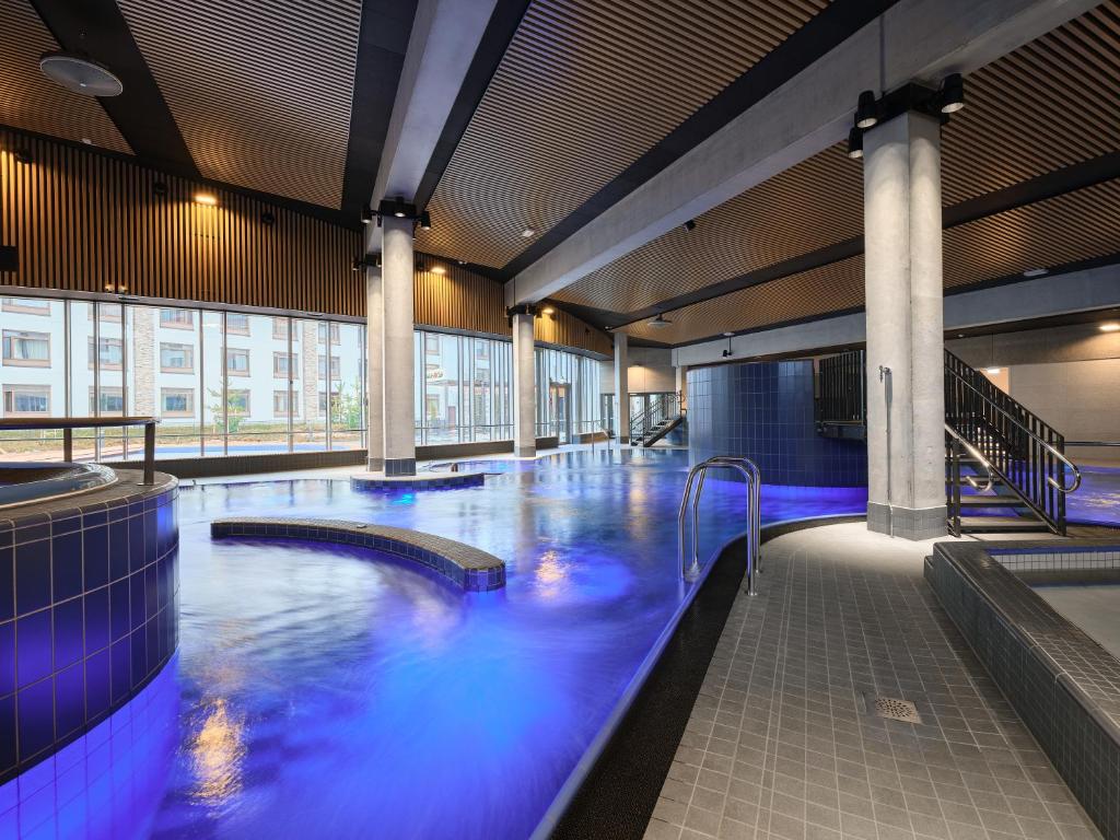 a large swimming pool with blue lights in a building at Holiday Club Vierumäki in Vierumäki