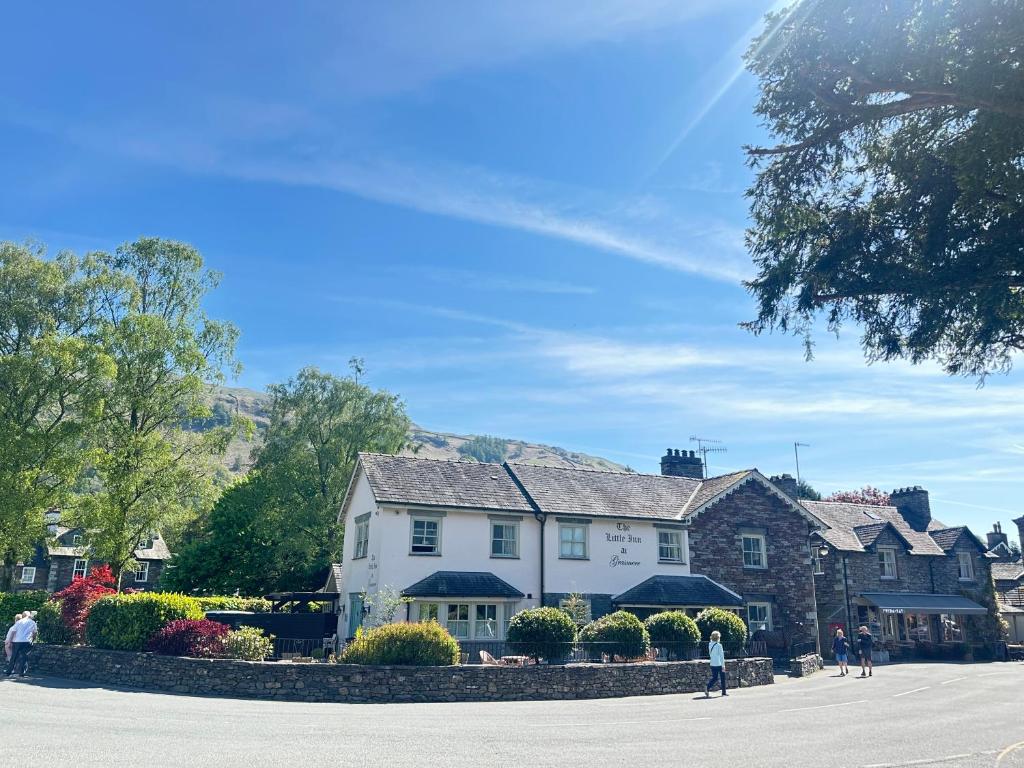 a group of houses in a town with people walking at The Little Inn at Grasmere in Grasmere