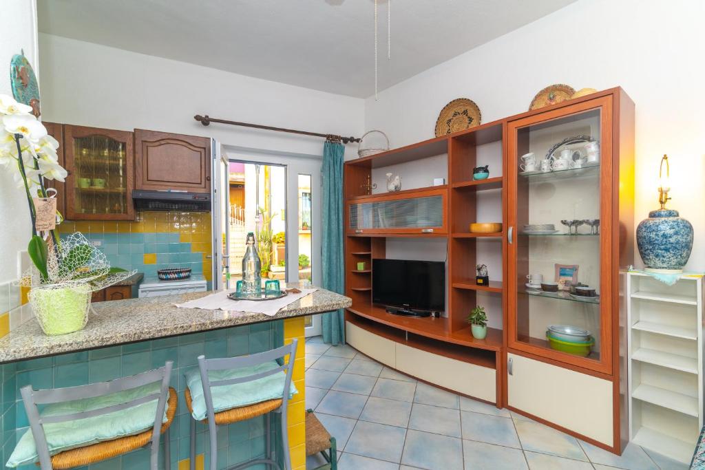 a kitchen with wooden cabinets and a counter at Smeraldo Beach in Santa Teresa Gallura