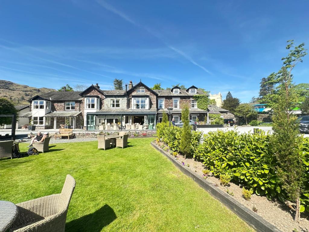 una grande casa con un prato verde davanti di Bridge House Hotel & Silver Howe View Cottage a Grasmere