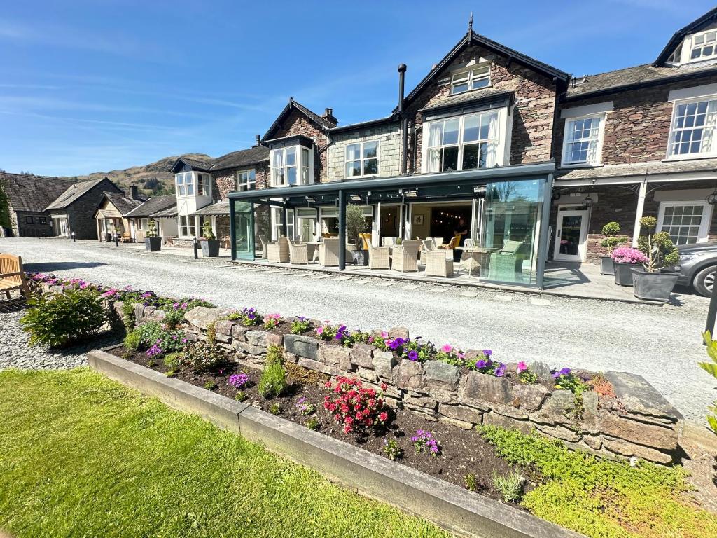 una casa con dei fiori davanti di Bridge House Hotel & Silver Howe View Cottage a Grasmere