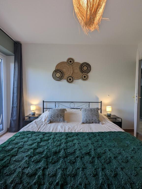 une chambre avec un grand lit avec une couverture verte dans l'établissement Confortable et moderne avec clim et jardin privé - Appartement Sauge, à Thonon-les-Bains