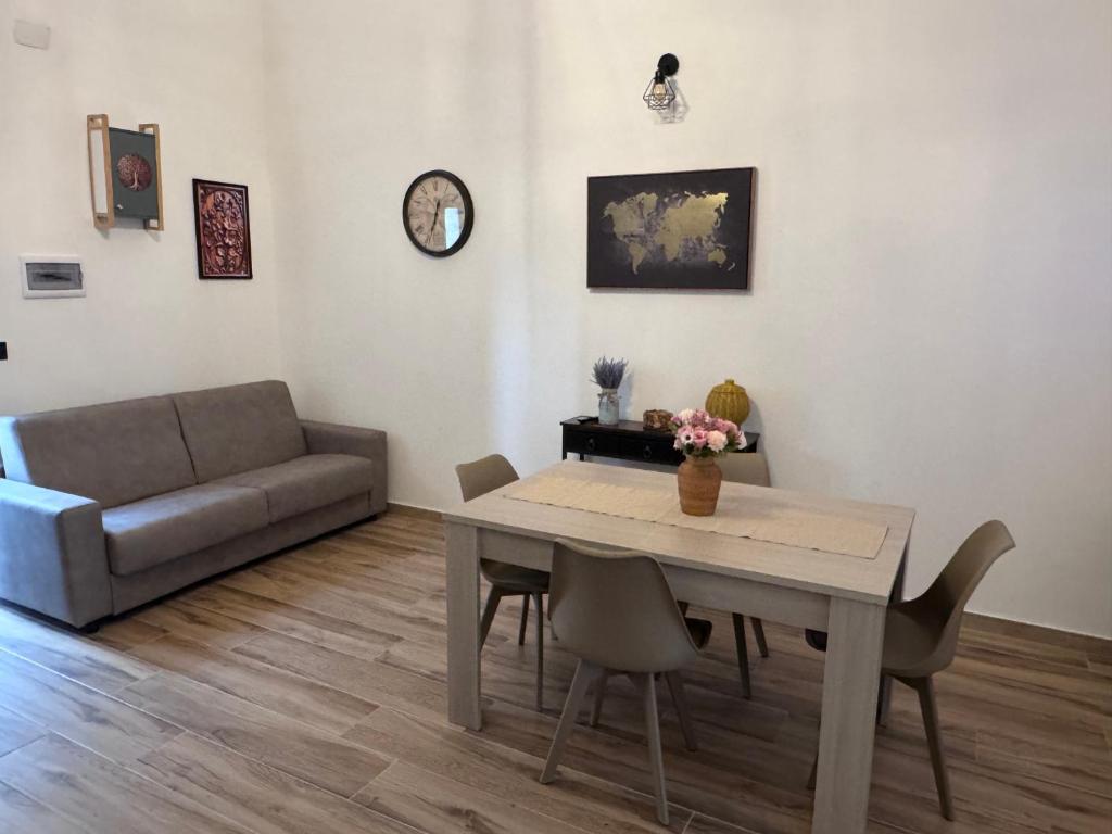 un soggiorno con un tavolo e un divano di La Casa sul Corso a Talsano