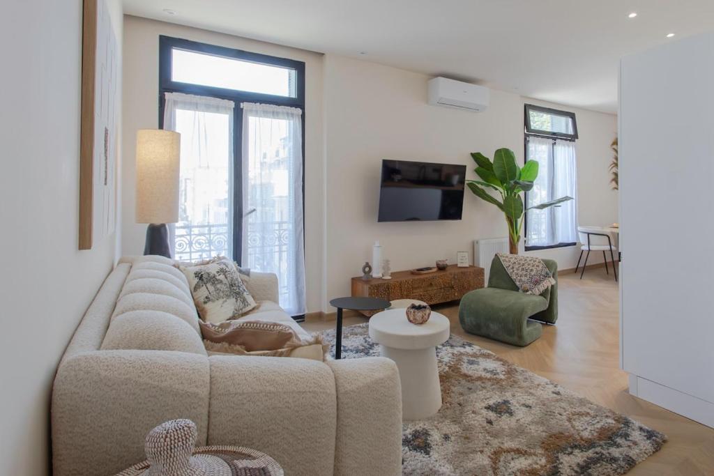 un salon avec un canapé et une télévision dans l'établissement #52 Etoile Suite ,Central, Balcony, AC-5 min P Massena, à Nice