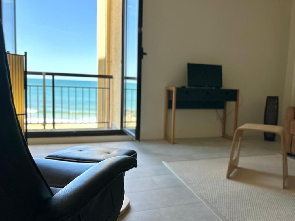 un salon avec un canapé et une vue sur l'océan dans l'établissement Vue mer et plage à pied, à Capbreton