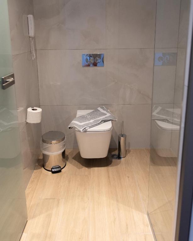 a bathroom with a toilet and a glass shower at Nireus Hotel in Symi