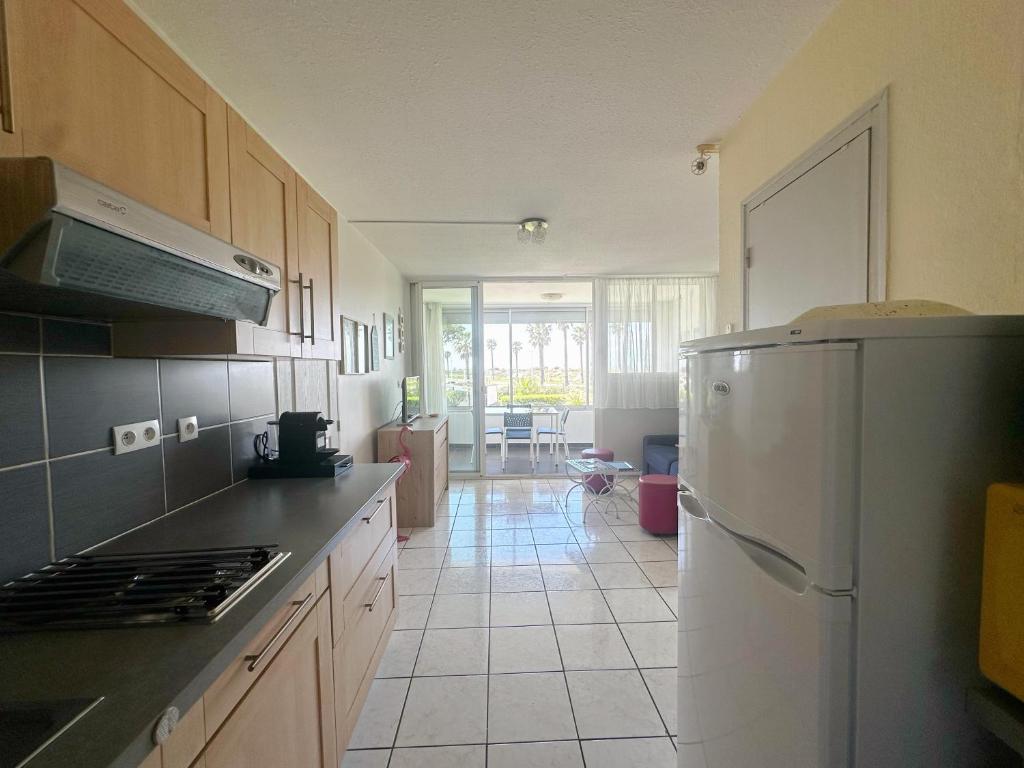 une cuisine avec un réfrigérateur et un plan de travail dans l'établissement Cocon au Grau-du-Roi Calme, lumineux, à 200m de la plage, au Grau-du-Roi