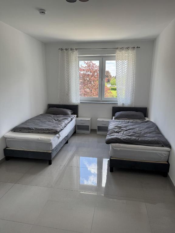 a bedroom with two beds and a window at GM Ferienwohnung 1 in Ochtrup