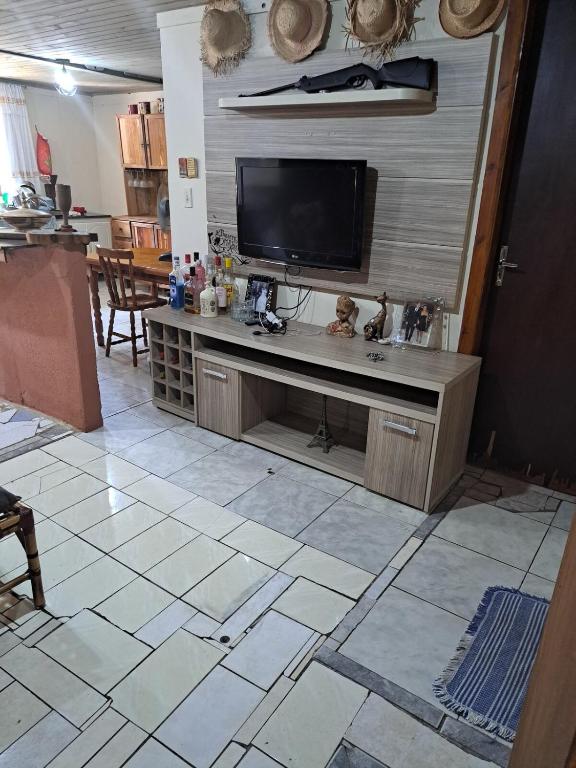 a living room with a flat screen tv on a wall at Chácara gratidão a Deus in Morretes