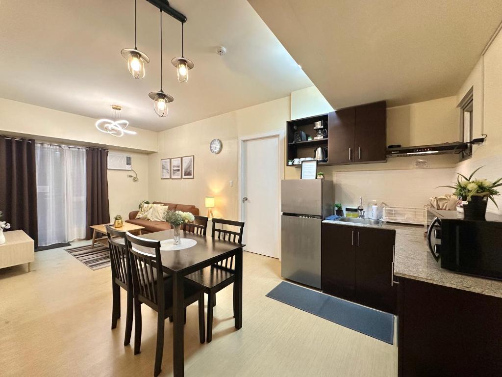 a kitchen and a living room with a table and chairs at 2-Bedroom Condo Unit with Balcony at Centrio Tower beside Ayala Centrio Mall Downtown CDO in Cagayan de Oro