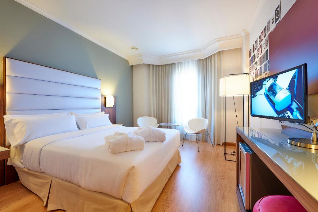 a hotel room with two beds and a television at Hotel Vigo Los Galeones Affiliated by Meliá in Vigo