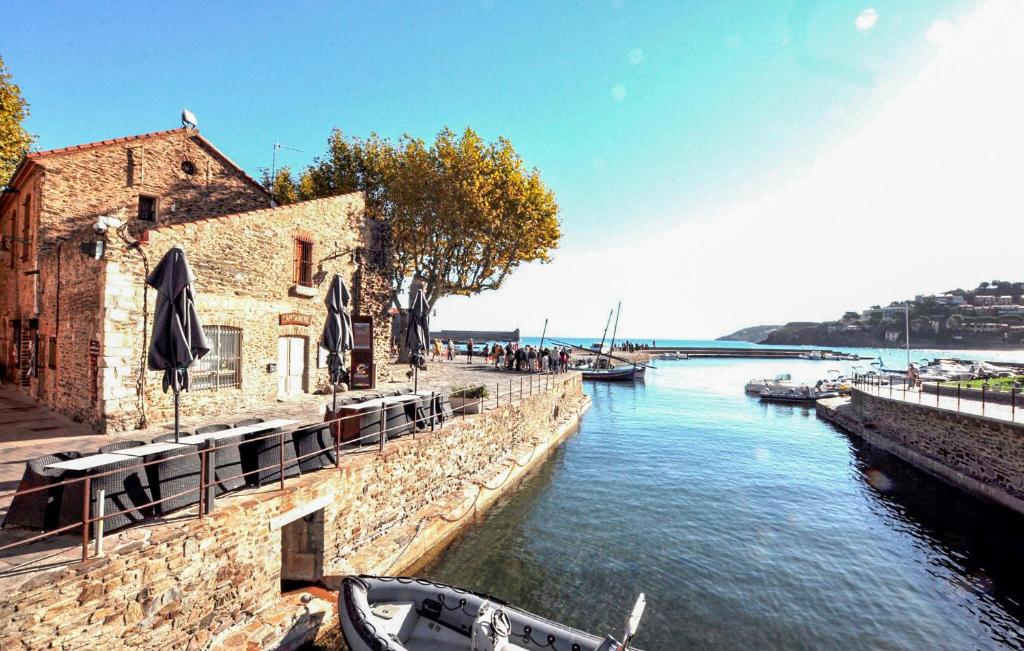 a river with a building and a boat in the water at Gorgeous Apartment In Port-Vendres in Port-Vendres