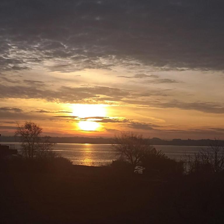 a sunset over a body of water with the sun at Chalet Lestraouen in Plougastel-Daoulas