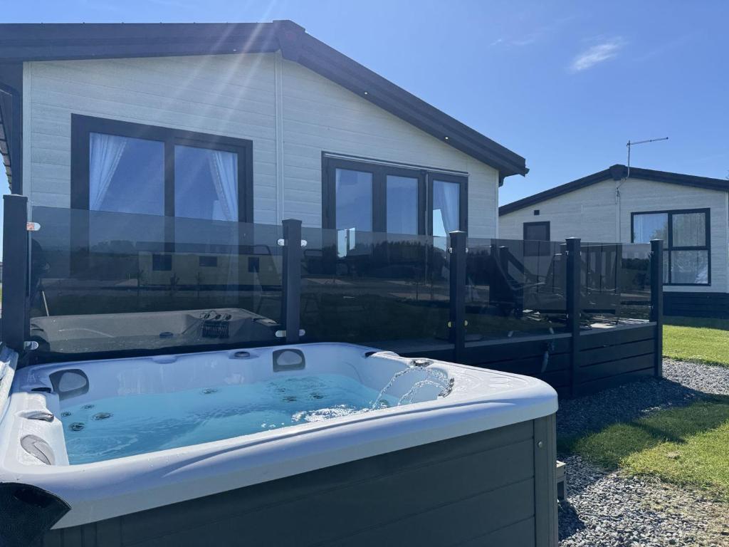 - un bain à remous dans une cour en face d'une maison dans l'établissement Stewarts Resort Lodge 59, à St Andrews