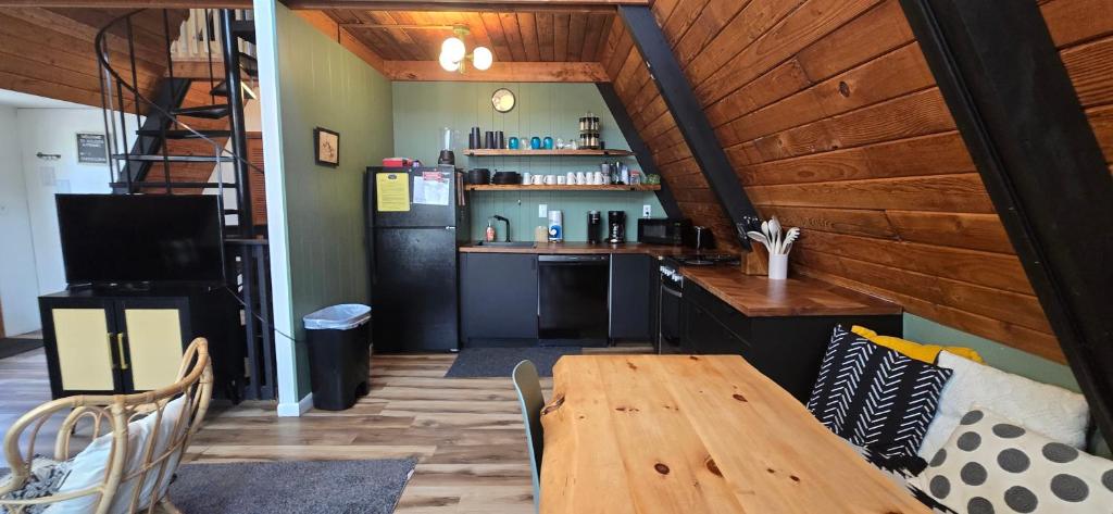 a dining room with a wooden table and a kitchen at Golden A Frame- 3 bedroom with hot tub and community amenities in Swanton