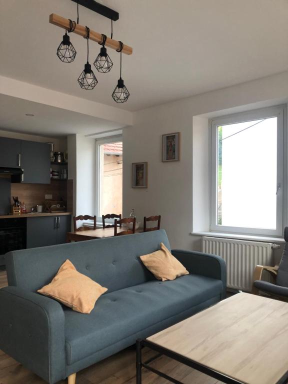 un salon avec un canapé bleu et une table dans l'établissement Wilson A2, à Sainte-Marie-aux-Mines