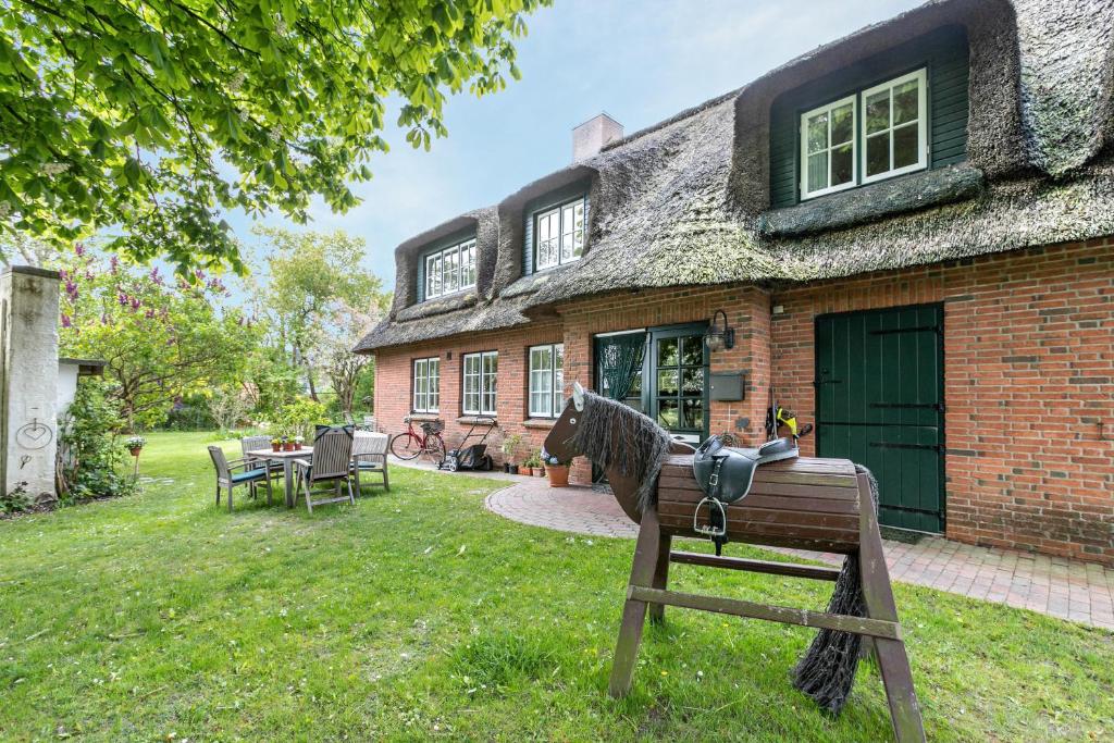 a horse is standing in front of a house at Das Deichhaus in Norddeich