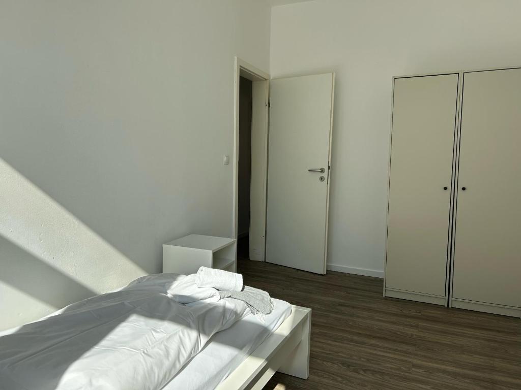 a white bedroom with a bed and two closets at Convenient Apartment for 3 in Offenbach