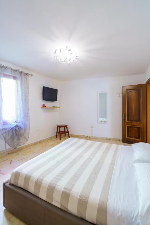 a bedroom with a large bed with a tv on the wall at Da Rocky in Riomaggiore