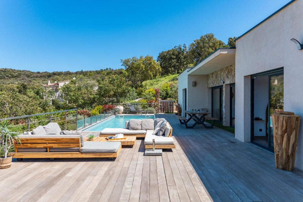 une terrasse en bois avec des canapés et une piscine dans l'établissement Villa Tinoeva, à Conca