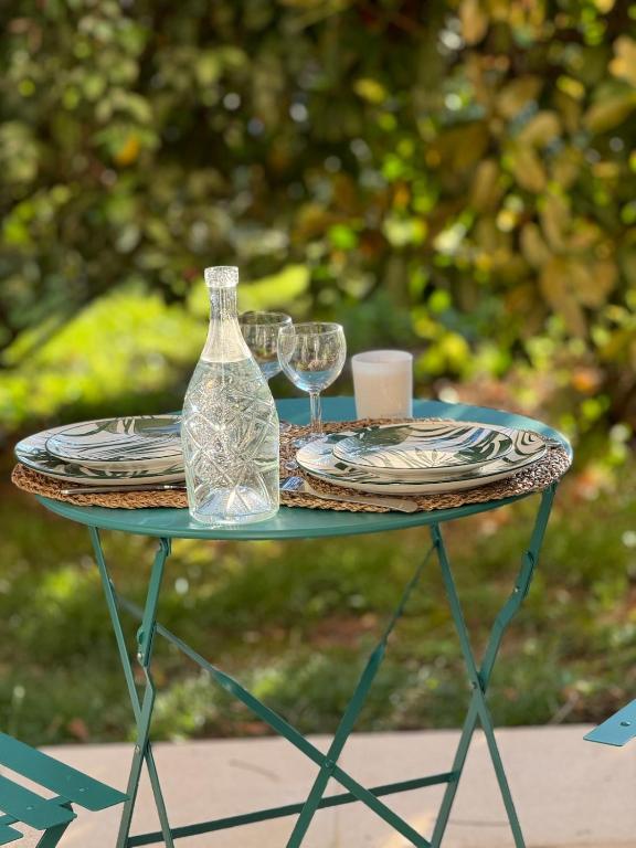 - une table avec deux verres et une bouteille dans l'établissement L'Ecrin du Parc By Villa Gaïa - Terrasse et parc en centre ville, proche Eurexpo - Groupama - LDLC Arena - Aéroport, à Genas