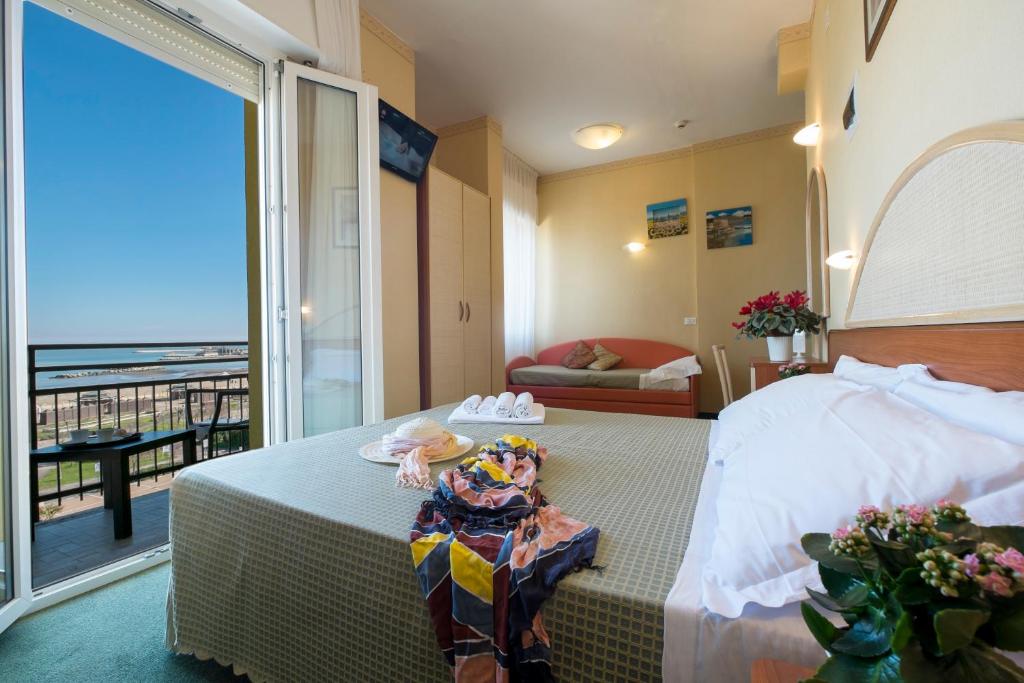 a bedroom with a bed with a view of the ocean at Hotel Crosal in Rimini