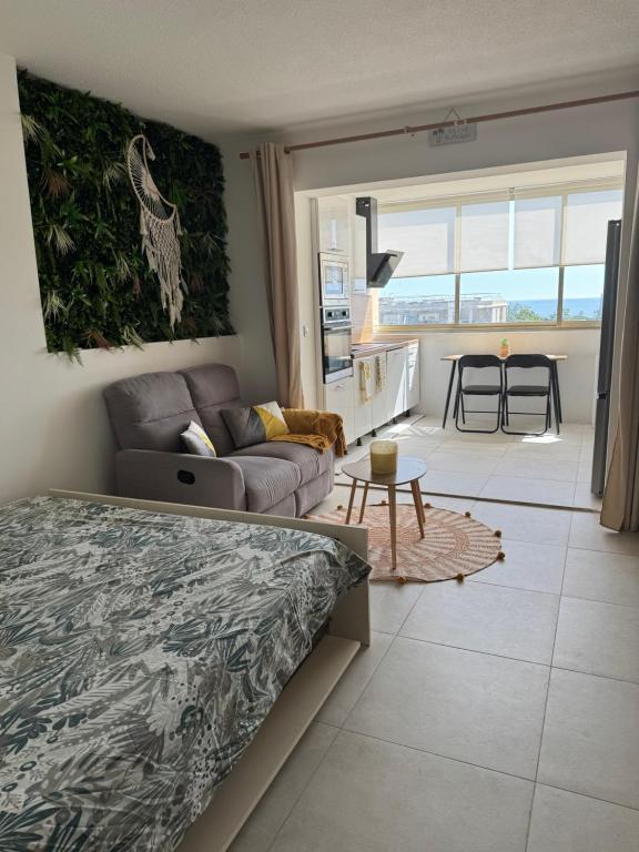 une chambre avec un lit et un salon dans l'établissement Studio Cosy vue mer, à Antibes