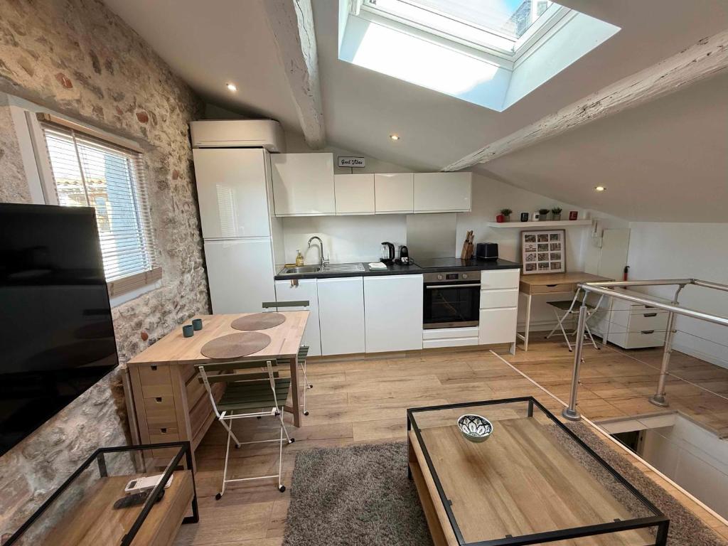d'une cuisine avec des placards blancs, une table et une lucarne. dans l'établissement Lovely One-Bedroom Apt- Picasso 4 -Stay In Antibes, à Antibes