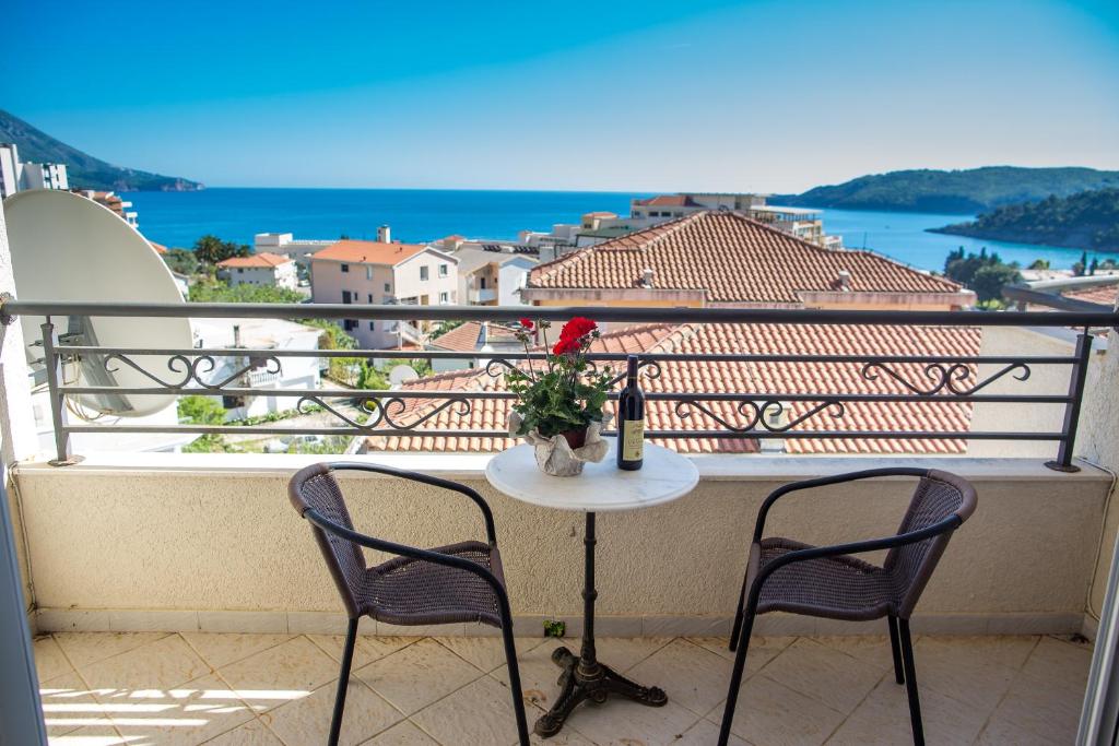 a table with a vase of flowers on a balcony at Apartments Charme in Bečići