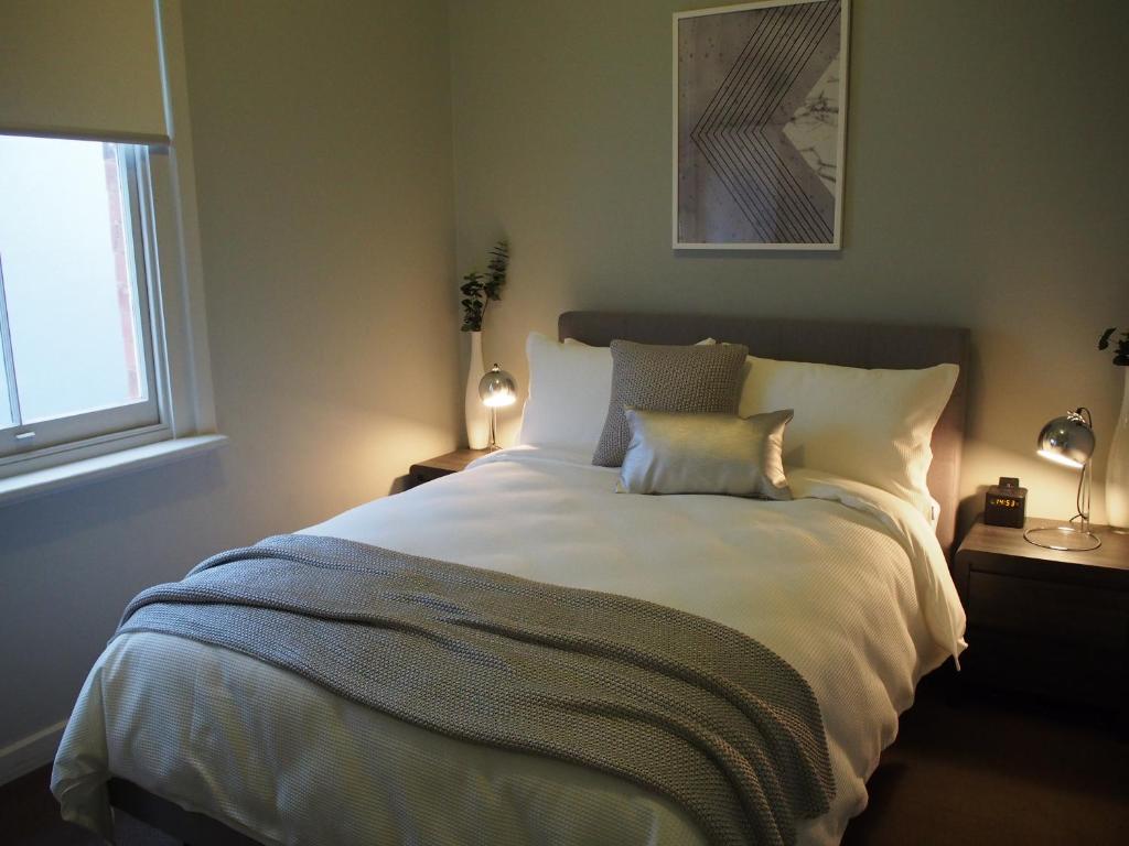 sypialnia z dużym białym łóżkiem i oknem w obiekcie City Quarters on Brewer w mieście Perth