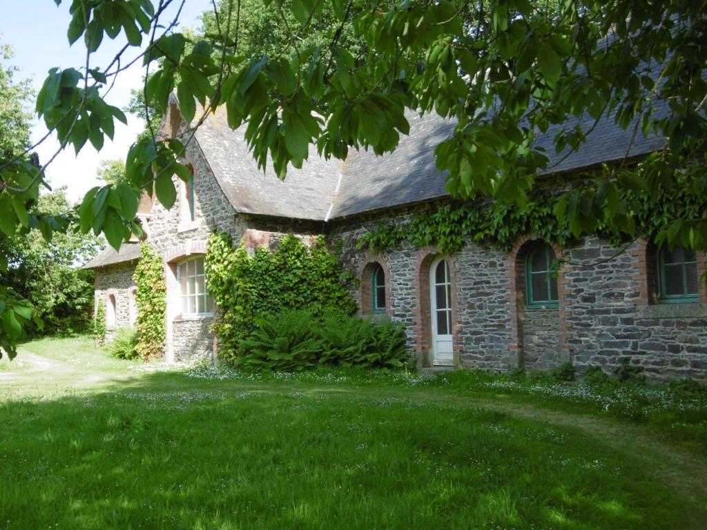 une ancienne maison en pierre avec une cour verdoyante dans l'établissement La Bergerie - Manoir de Kerhir, à La Celle-sous-Gouzon